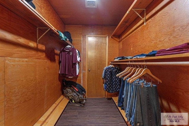 walk in closet with dark wood-type flooring