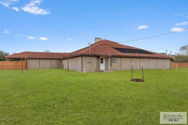 rear view of house featuring a lawn