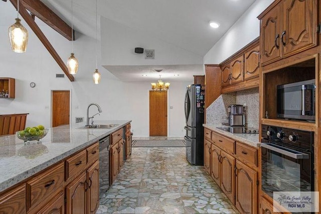 kitchen with light stone counters, hanging light fixtures, black appliances, and sink