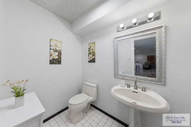 bathroom with sink, tile patterned floors, a textured ceiling, and toilet