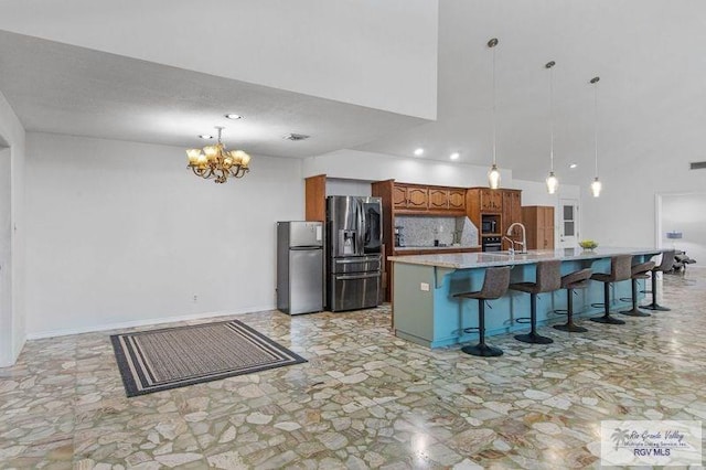 kitchen with a breakfast bar, sink, stainless steel fridge with ice dispenser, stainless steel fridge, and a kitchen island with sink