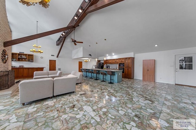 living room with beamed ceiling, ceiling fan with notable chandelier, and high vaulted ceiling