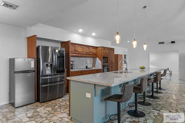 kitchen with sink, backsplash, hanging light fixtures, a kitchen island with sink, and black appliances