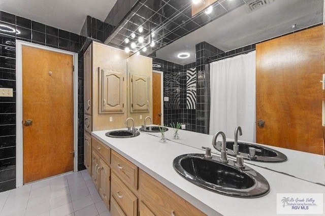 bathroom with a shower with shower curtain, vanity, and tile patterned flooring