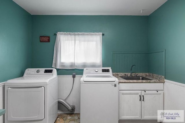 laundry room with sink, washer and clothes dryer, and cabinets