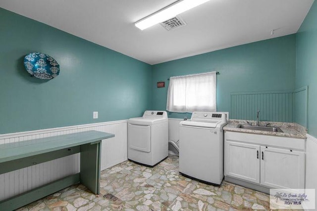 laundry area with cabinets, washing machine and dryer, and sink