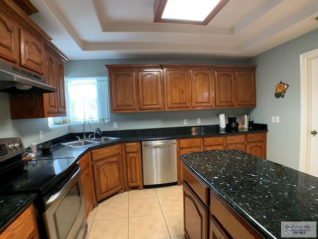 kitchen featuring sink, light tile patterned floors, stainless steel appliances, and a tray ceiling