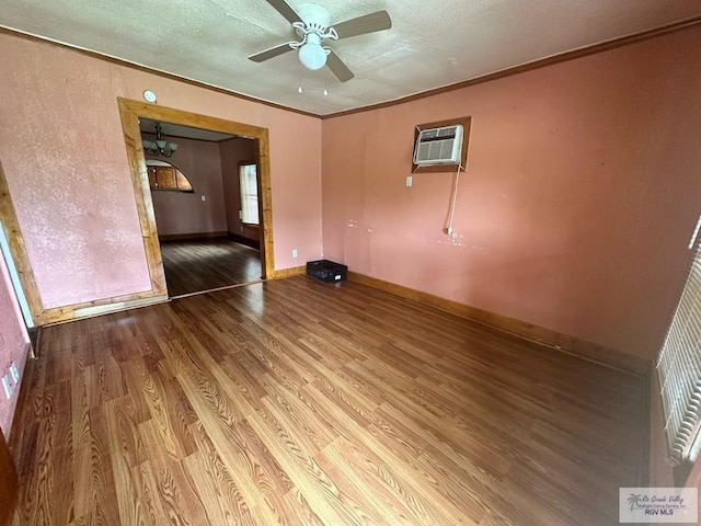 1022 E Monroe Ave, Harlingen, TX 78550 - spare room with wood finished floors, a ceiling fan, a wall mounted AC, baseboards, and ornamental molding