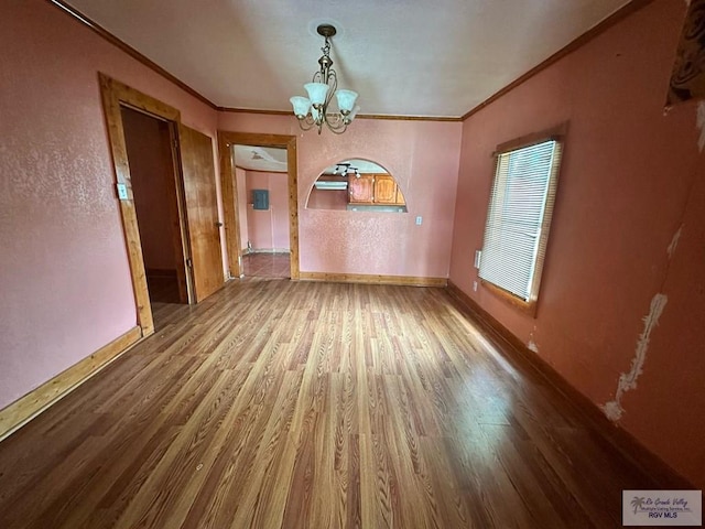 1022 E Monroe Ave, Harlingen, TX 78550 - unfurnished dining area with a chandelier, ornamental molding, wood finished floors, baseboards, and arched walkways