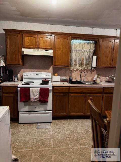 kitchen with tasteful backsplash, washer / clothes dryer, sink, and white range with electric stovetop