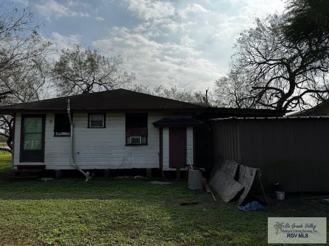 back of property featuring cooling unit and a lawn