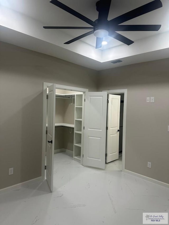 unfurnished bedroom featuring marble finish floor, baseboards, visible vents, and ceiling fan