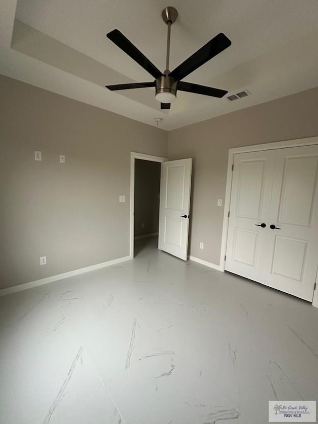 unfurnished bedroom with a closet, marble finish floor, visible vents, and baseboards