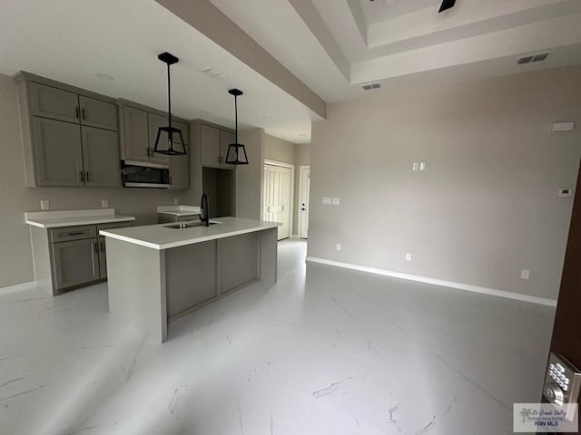 kitchen featuring a sink, visible vents, marble finish floor, gray cabinets, and stainless steel microwave