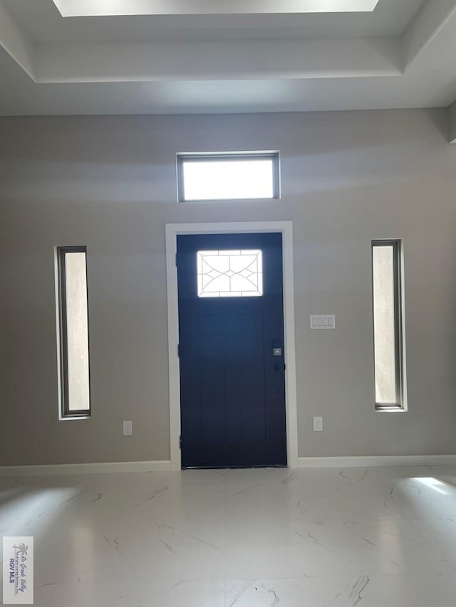 foyer with marble finish floor and baseboards