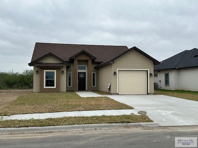 view of front facade with a garage, driveway, a front lawn, and stucco siding