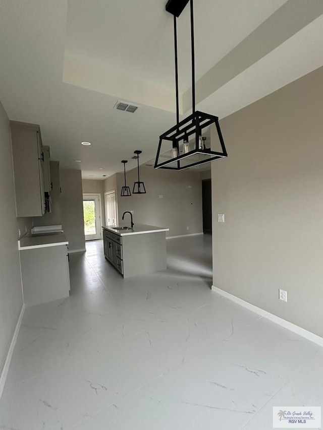 kitchen featuring marble finish floor, visible vents, a sink, and baseboards