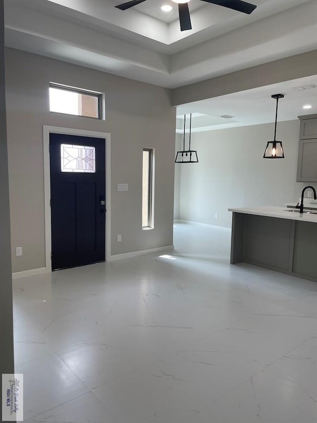 entryway with marble finish floor, ceiling fan, and baseboards