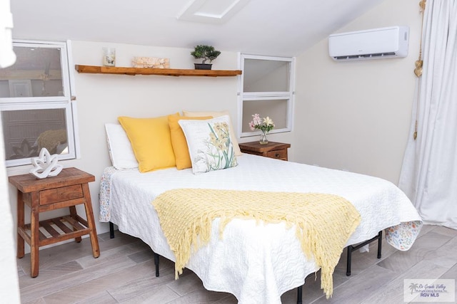 bedroom with light hardwood / wood-style flooring and a wall mounted air conditioner