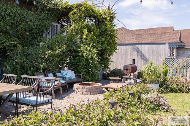 view of patio with an outdoor living space with a fire pit