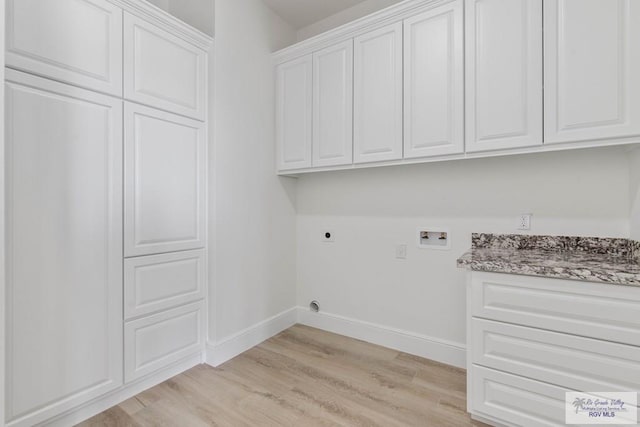 washroom featuring light wood-style flooring, electric dryer hookup, cabinet space, washer hookup, and baseboards