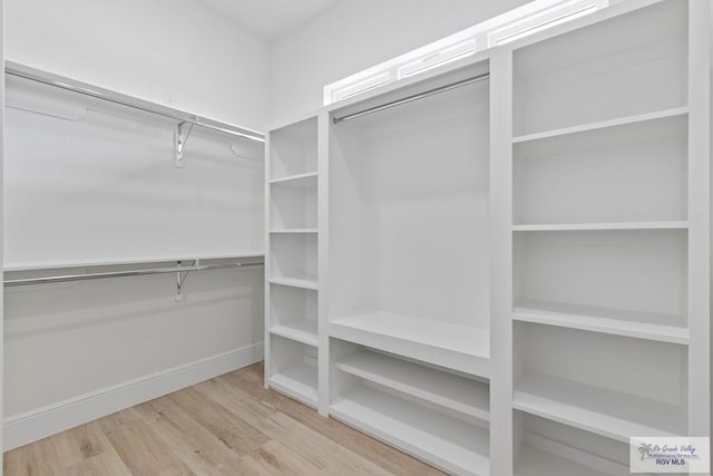 walk in closet with wood finished floors