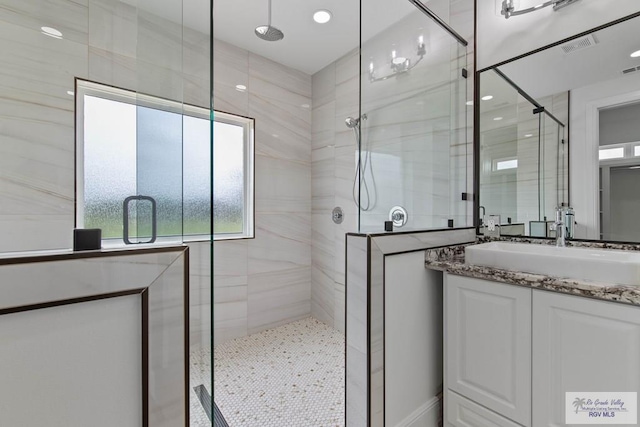 bathroom with vanity, a shower stall, and visible vents