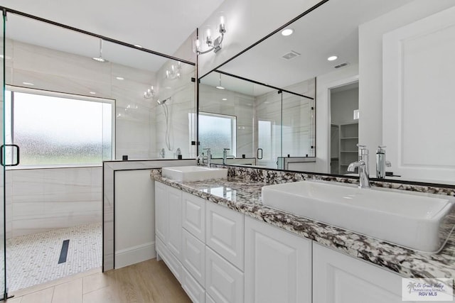 full bathroom with a stall shower, recessed lighting, a sink, and visible vents
