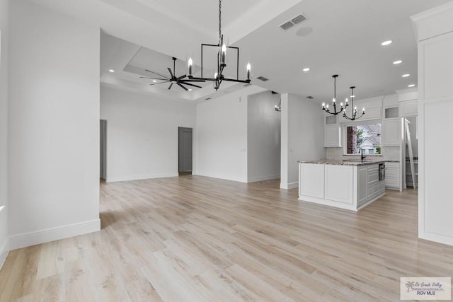 interior space with light wood-style flooring, a chandelier, visible vents, baseboards, and recessed lighting