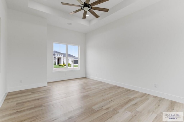 unfurnished room with recessed lighting, light wood-style floors, ceiling fan, baseboards, and a raised ceiling