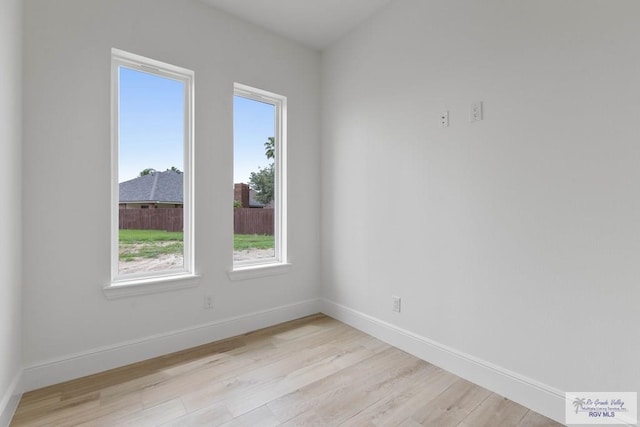 unfurnished room with baseboards and light wood-style floors
