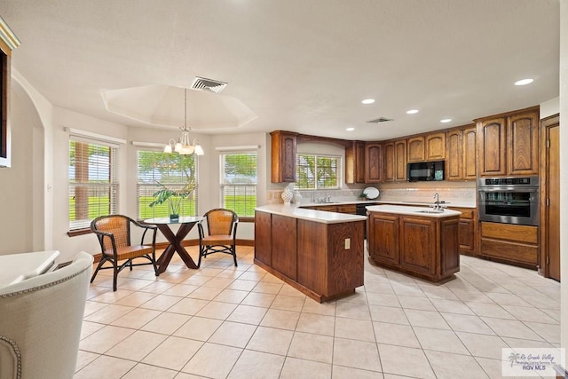 14823 S Valencia Cir, Harlingen, TX 78552 - kitchen with stainless steel oven, black microwave, light tile patterned flooring, light countertops, and backsplash