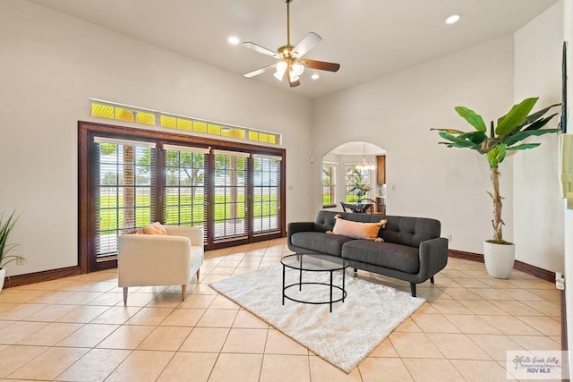 14823 S Valencia Cir, Harlingen, TX 78552 - living area with arched walkways, light tile patterned floors, ceiling fan, recessed lighting, and a towering ceiling