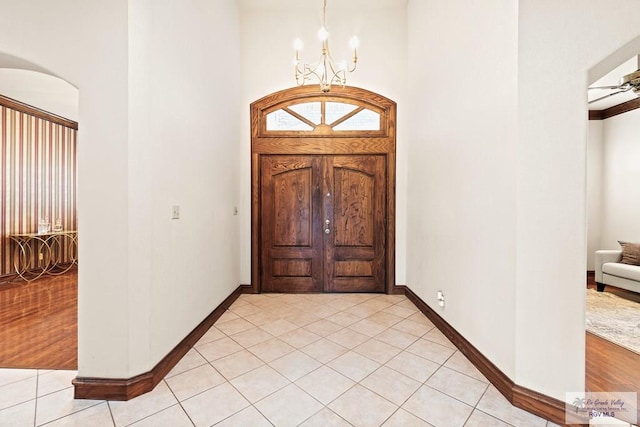 14823 S Valencia Cir, Harlingen, TX 78552 - foyer with a chandelier, a towering ceiling, light tile patterned floors, and arched walkways