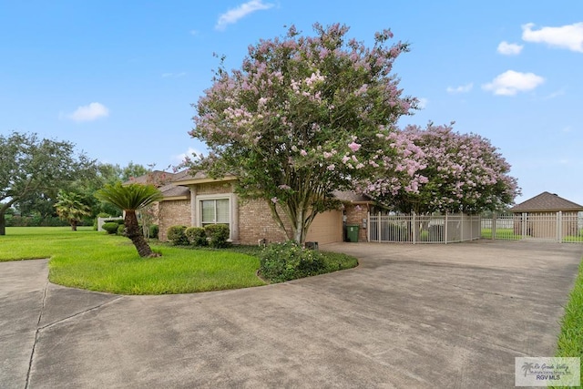 14823 S Valencia Cir, Harlingen, TX 78552 - obstructed view of property featuring driveway, brick siding, and an attached garage