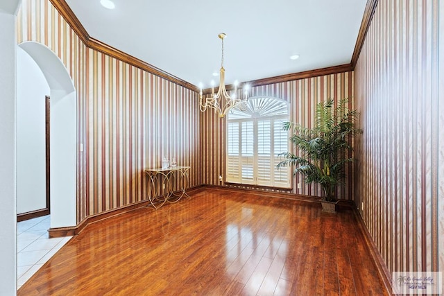 14823 S Valencia Cir, Harlingen, TX 78552 - unfurnished room featuring a chandelier, hardwood / wood-style floors, arched walkways, and crown molding