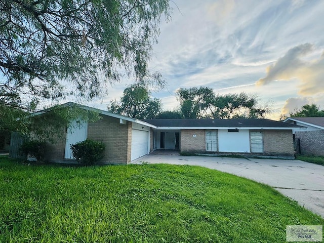 20 Casa Linda Unit 20, Brownsville, TX 78526 - ranch-style house with brick siding, a garage, a lawn, and driveway