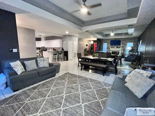 1822 Nasa, Brownsville, TX 78521 - tiled living room with a ceiling fan, a raised ceiling, and a glass covered fireplace