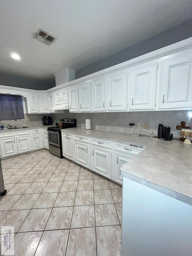 1822 Nasa, Brownsville, TX 78521 - kitchen featuring stainless steel range with electric stovetop, under cabinet range hood, light countertops, and white cabinetry