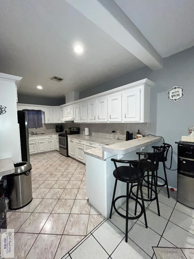 1822 Nasa, Brownsville, TX 78521 - kitchen with stainless steel electric stove, a peninsula, light countertops, white cabinetry, and black refrigerator
