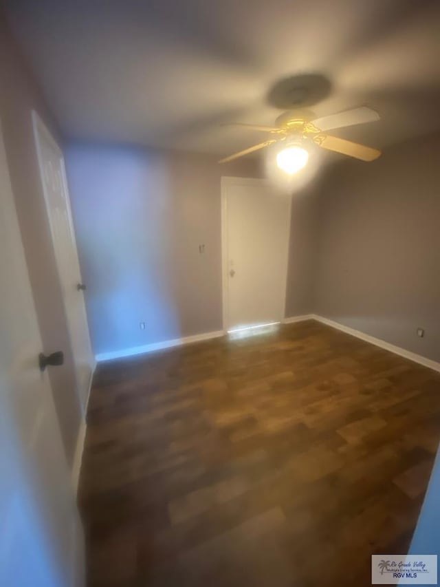 empty room featuring dark hardwood / wood-style flooring and ceiling fan