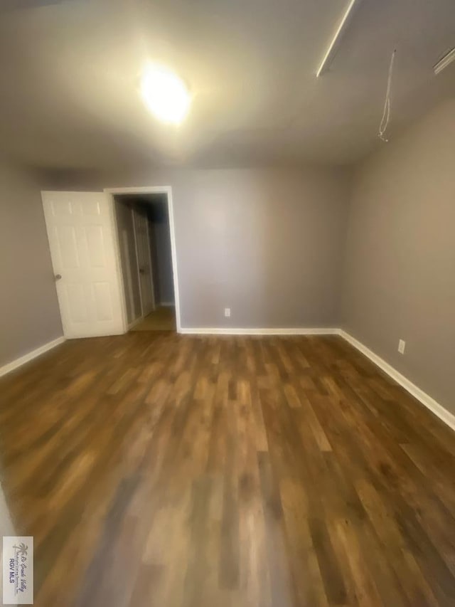 unfurnished room featuring dark wood-type flooring