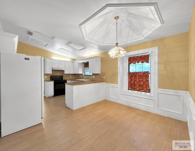 kitchen featuring white refrigerator, black range with electric stovetop, light wood-type flooring, decorative light fixtures, and white cabinetry