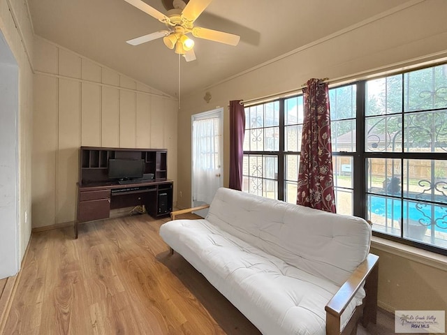 living room with light hardwood / wood-style flooring, vaulted ceiling, a wealth of natural light, and ceiling fan