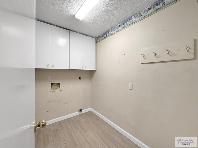 washroom with cabinets, hookup for a washing machine, light hardwood / wood-style flooring, a textured ceiling, and hookup for an electric dryer