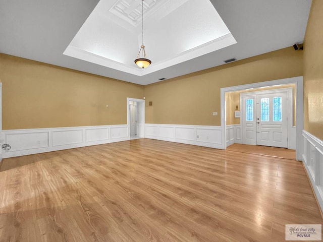 interior space featuring light hardwood / wood-style floors and a raised ceiling