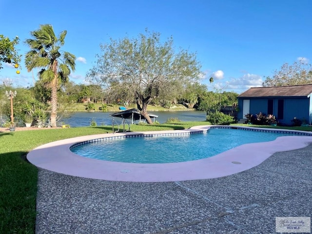 view of pool with a lawn and a water view