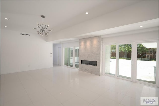 unfurnished living room featuring a fireplace, light tile patterned flooring, and a notable chandelier