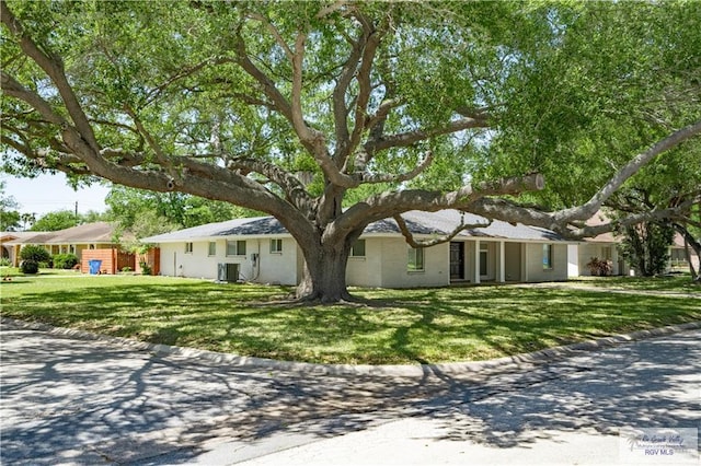 ranch-style house with central AC unit and a front yard