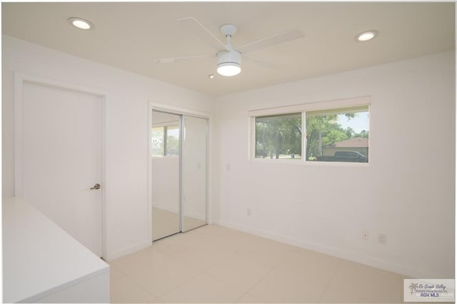 unfurnished bedroom with ceiling fan and a closet